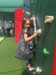 preschool graduate climbing on rock wall